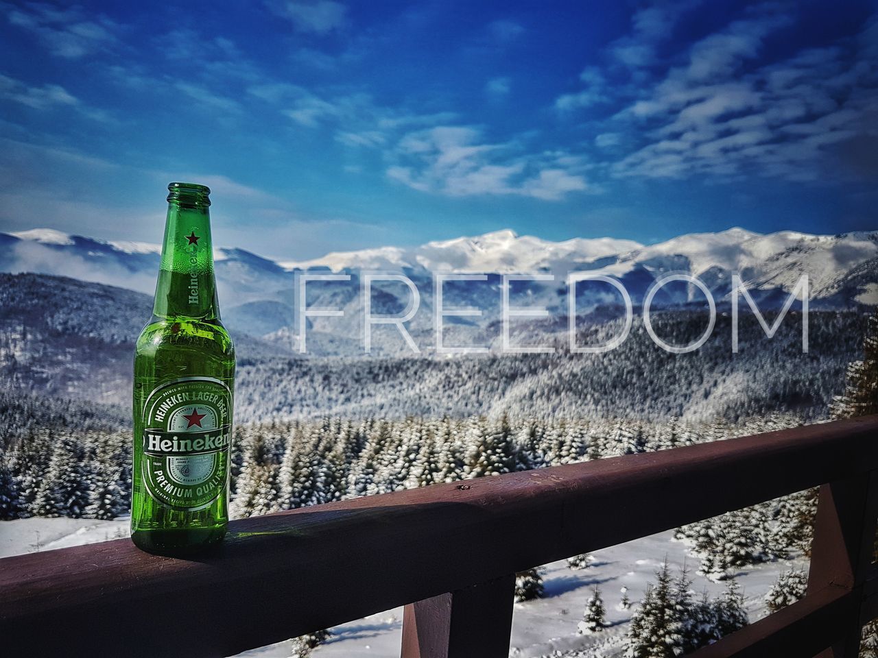 CLOSE-UP OF BEER BOTTLES AGAINST MOUNTAIN AND WATER