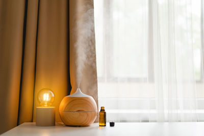 Aromatherapy concept. aroma oil diffuser on the table against the window.