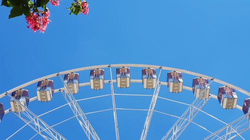 Low angle view of ferris wheel against clear blue sky