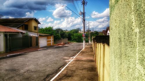 Empty road against cloudy sky