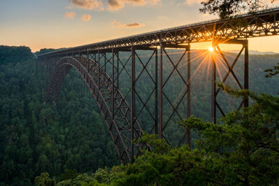 Bridge over river against sky during sunset