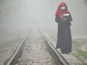 Woman standing on railroad track