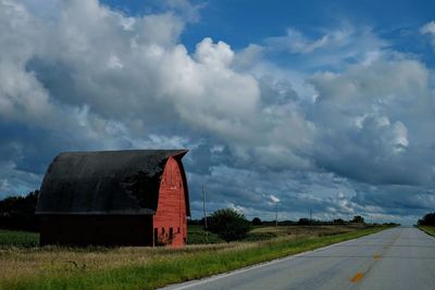 Road amidst field against sky