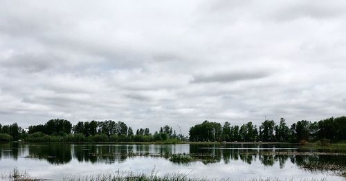 Scenic view of lake against cloudy sky