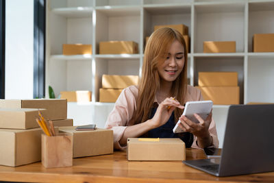 Midsection of woman using laptop at cafe