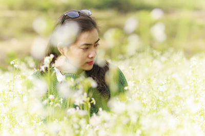 Close-up of teenage girl with flowers on field