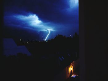 Illuminated lighting equipment against sky at night
