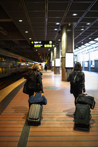 Women with suitcases at train station