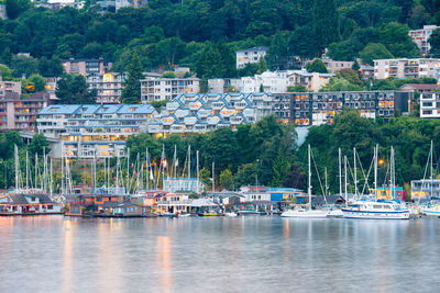 Boats moored in harbor against buildings in city