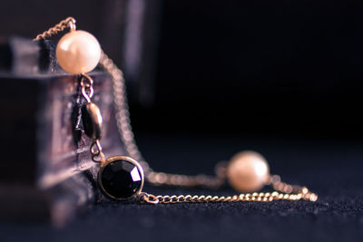 Close-up of necklace against black background