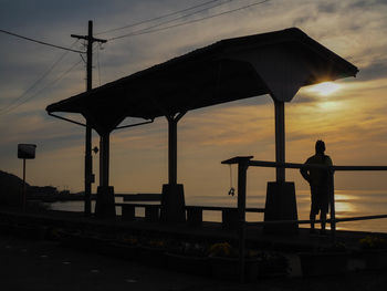 Silhouette man standing against orange sky