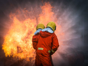 Rear view of man working on fire