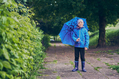 Full length of woman standing against trees