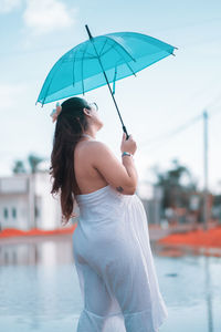 Side view of woman holding umbrella