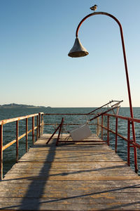 Pier over sea against clear sky