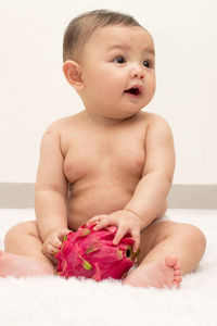 Cute baby boy sitting on bed