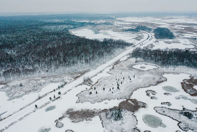 High angle view of snow covered shore against sky
