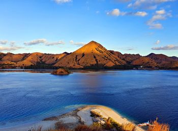 Scenic view of sea and mountains against blue sky