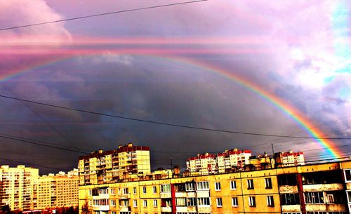 Low angle view of rainbow over residential buildings