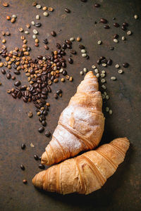 Directly above view of croissants with coffee beans on table