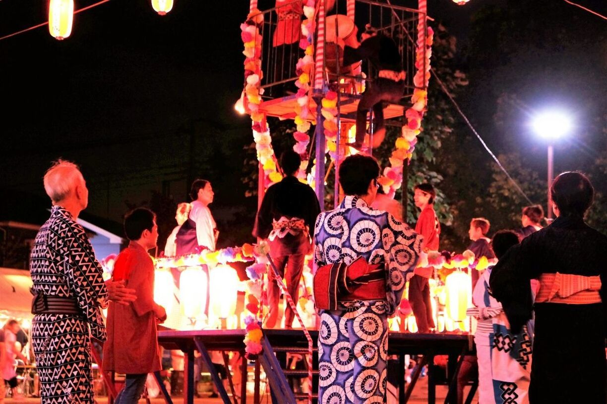 PEOPLE STANDING IN ILLUMINATED TEMPLE