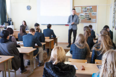 Rear view of students sitting in classroom