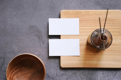 Directly above shot of blank visiting card by bottle on table