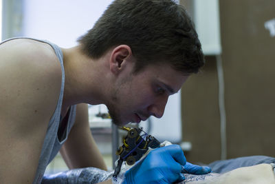 Close-up of man tattoing