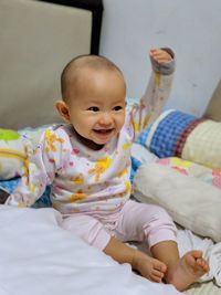 Portrait of cute baby girl on bed