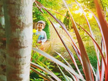 Portrait of boy on tree trunk