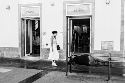 Rear view of woman walking by building