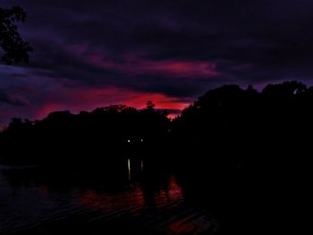 Silhouette river against sky at sunset