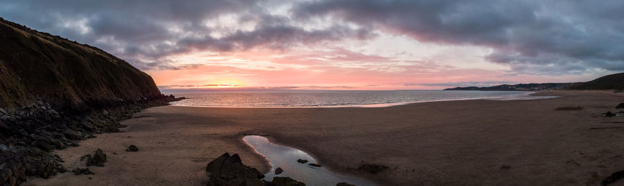 Scenic view of beach against sky during sunset