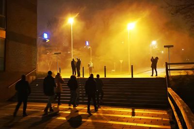 Group of people walking on street at night