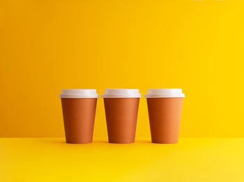 Close-up of coffee cup against yellow background