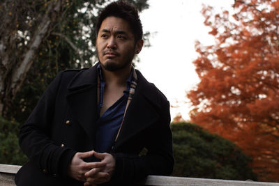 Portrait of pianist yi lin jiang sitting against trees