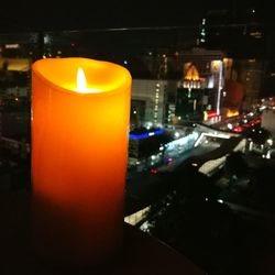 Close-up of lit candle at night