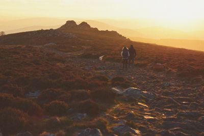 Man standing on mountain against sky during sunset