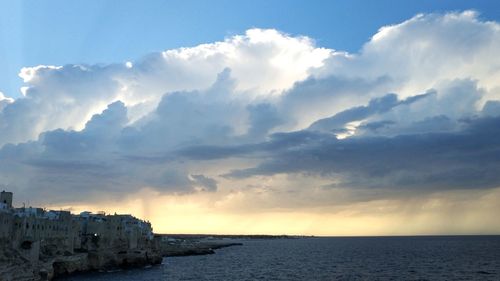 Scenic view of sea by buildings against sky