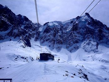 Snow covered mountain cable xar station against sky