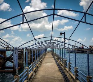 Bridge over river against cloudy sky