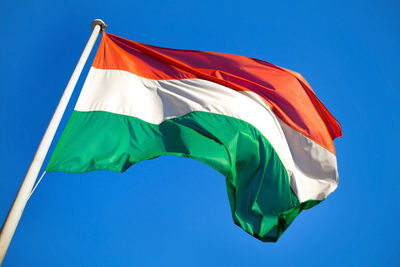 Low angle view of flag against blue sky