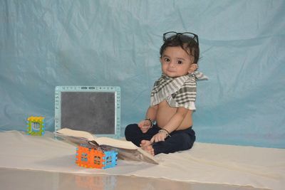 Cute girl sitting on table at home