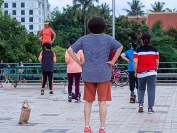 Rear view of people walking on footpath