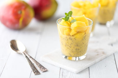 Refreshing mango chia pudding with others in soft focus in behind.