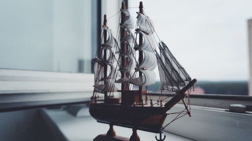 Figurine of sailboat on window sill at home