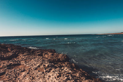 Scenic view of sea against clear blue sky