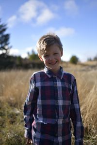 Portrait of happy boy standing on field