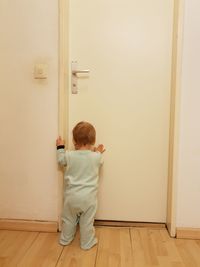 Rear view of boy against white wall