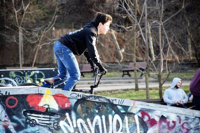 Side view of a young man skateboarding on car